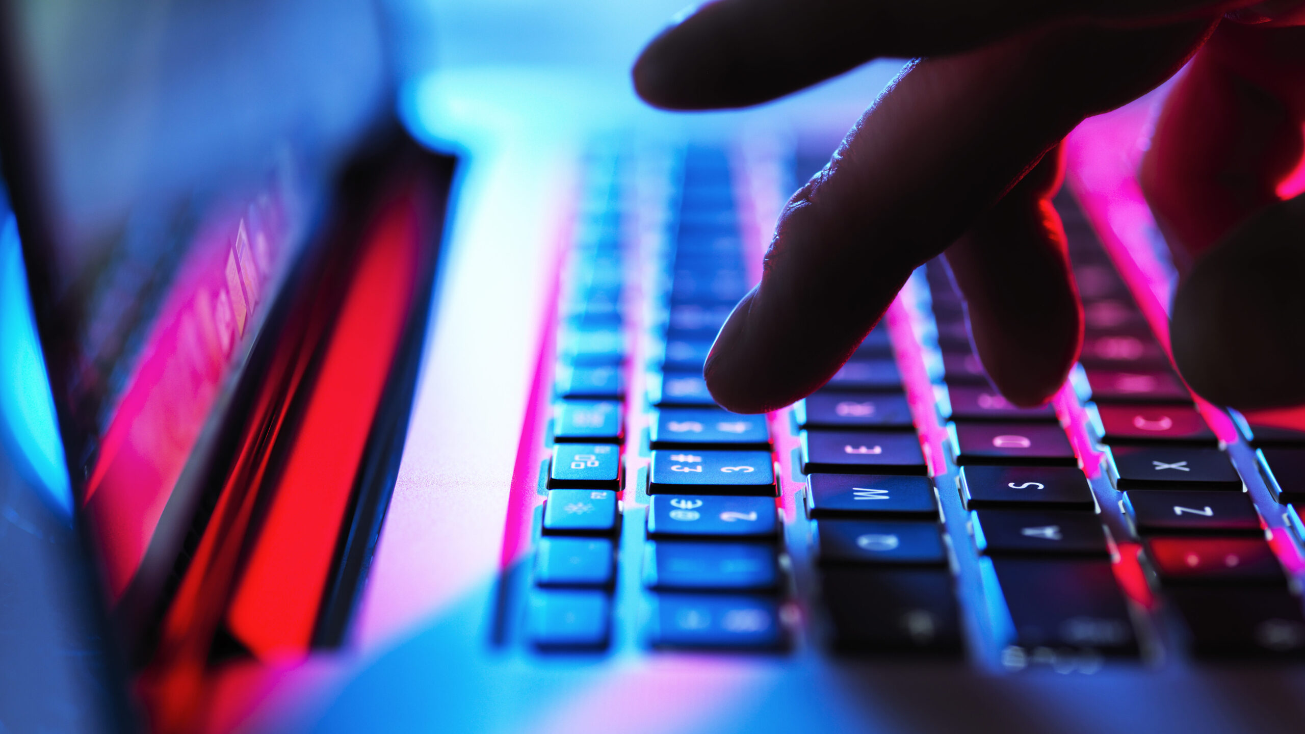 Close up of someone typing on a laptop keyboard.