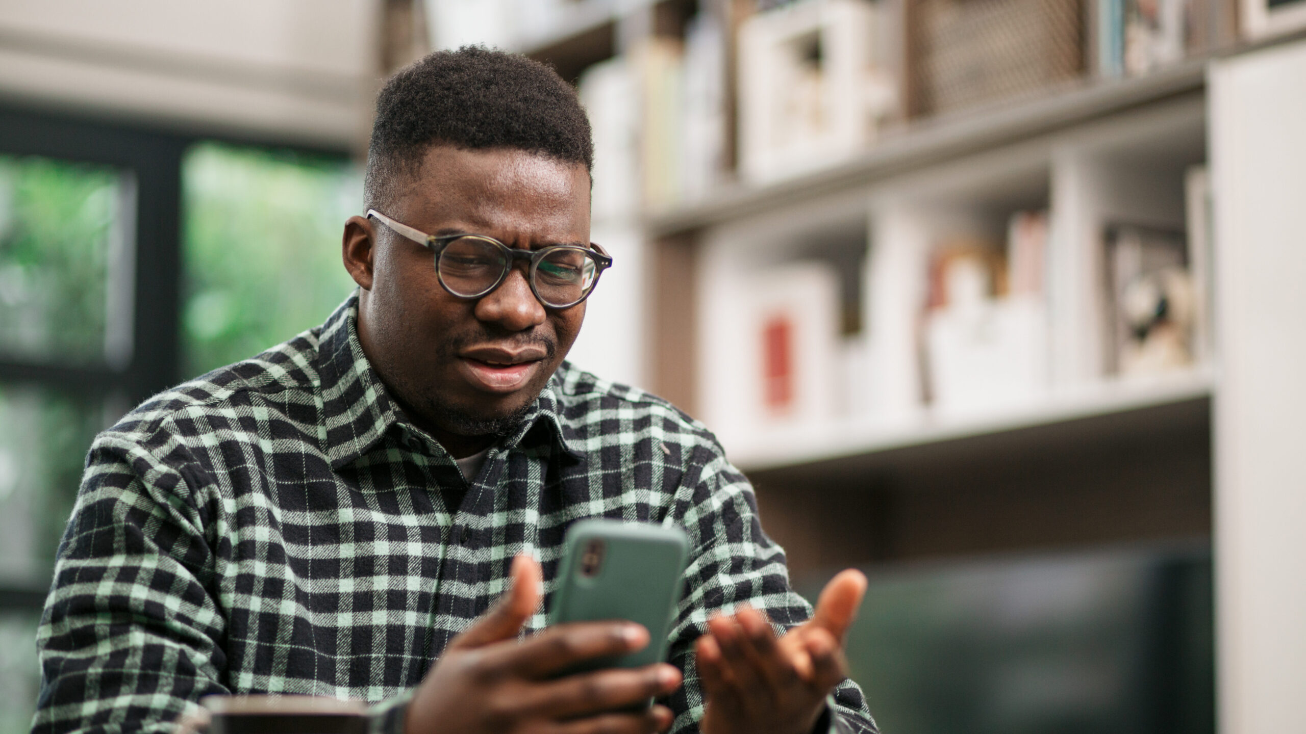 Young man looking in frustration at his mobile phone.
