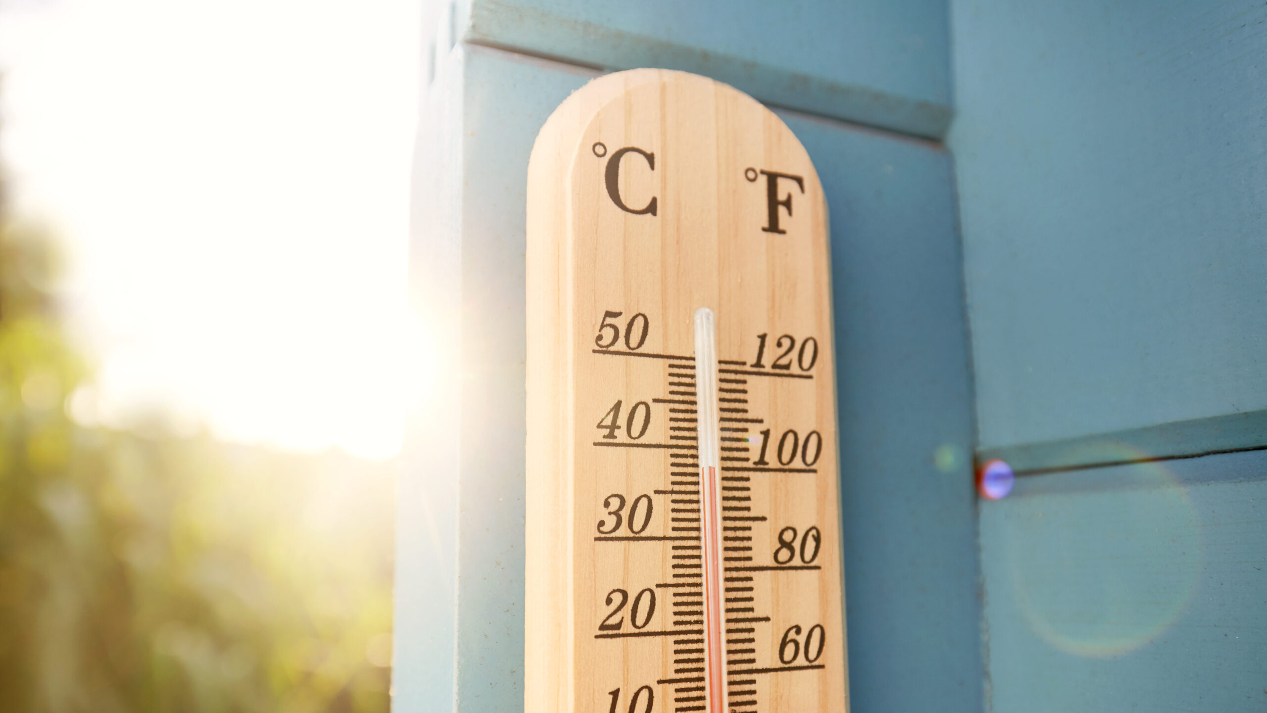 Thermometer depicting temperatures of 38℃ against a backdrop of bright skies.